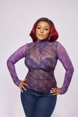 Model in the AKANTHA tie neck mesh top with the Plum & Grey monogram print