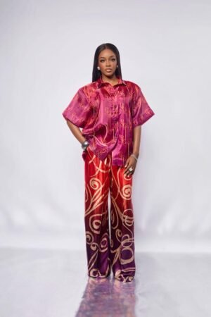 Model in the FARIDA wide-leg silk trousers in a red, orange and purple swirl print