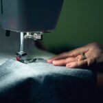 Hands guiding cloth through a sewing machine